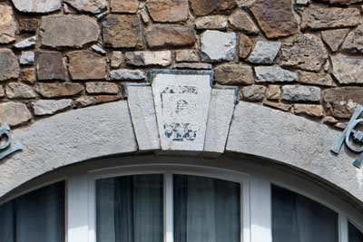 Hauszeichen von 1827 mit Christusmonogramm in Lorbeerkranz, Dorff, Pfarrer-Gau-Straße 27