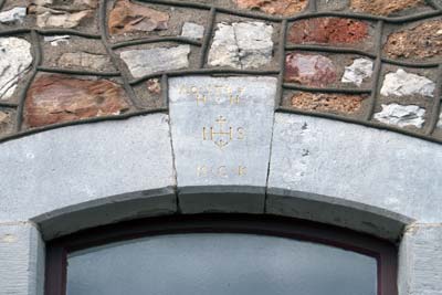 Büsbach, Hostetstraße 27-31 mit Hauszeichen und Hausfigur