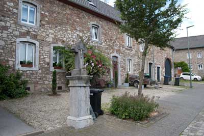 Büsbach, Hostetstraße 27-31 mit Hauszeichen und Hausfigur